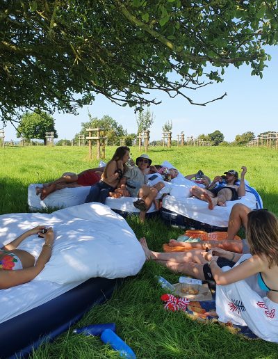 Guests relaxing in the orchard after a late night